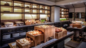 A buffet setup with various food items and serving utensils.