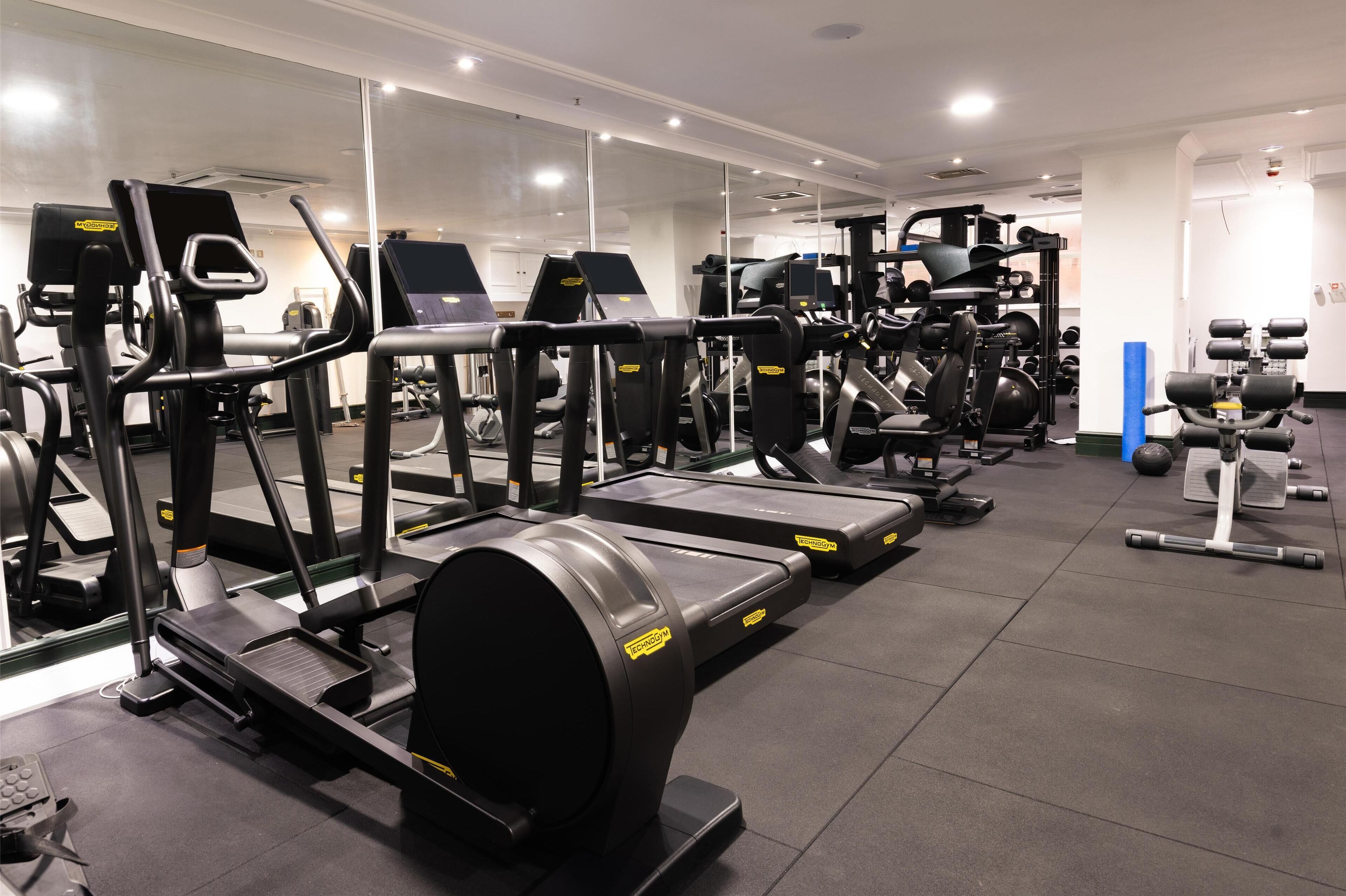 A gym with treadmills, weight machines, and free weights.