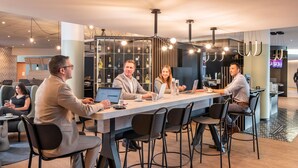 A modern conference room with a long table, multiple chairs, and laptops. - Novotel Marne-La-Vallée Noisy-Le-Grand (Noisy-le-Grand)