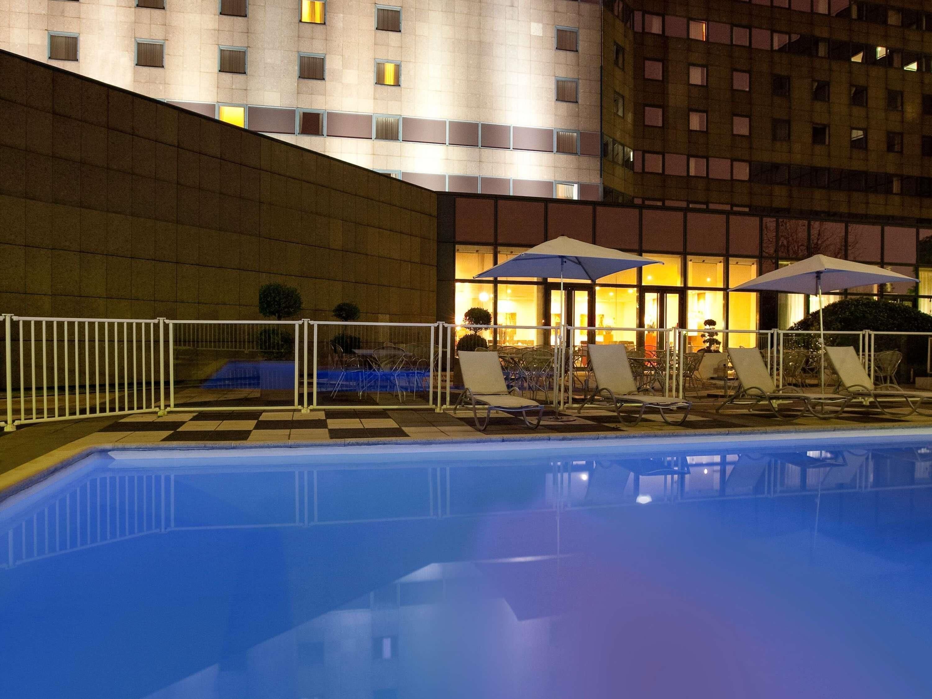 Una piscina al aire libre de temporada, sombrillas