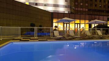 Una piscina al aire libre de temporada, sombrillas