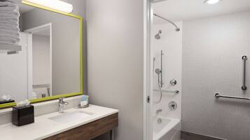 Een moderne badkamer met een witte wastafel, spiegel en douche.