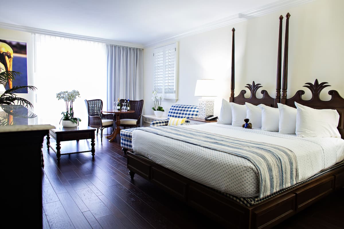 A spacious bedroom with a large bed, a desk, and a chair.