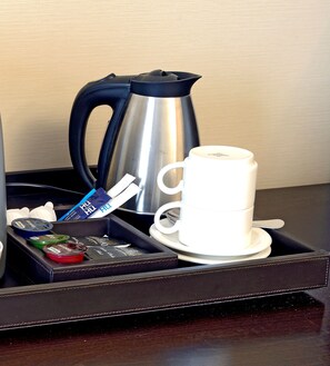 A tray with a white cup, a silver coffee pot, and various coffee pods. - NH Siena (Siena)
