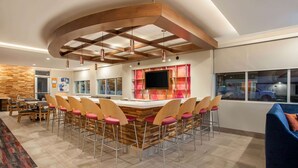 A modern kitchen with a central island, bar stools, and a large window. - La Quinta Inn & Suites by Wyndham Madera (Madera)