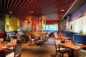 A restaurant interior with booths, tables, and a patterned floor. - Four Points by Sheraton Bakersfield (Bakersfield)