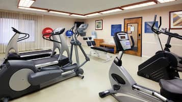 Centro de ginástica com esteiras, elípticos e bolas de exercício.
