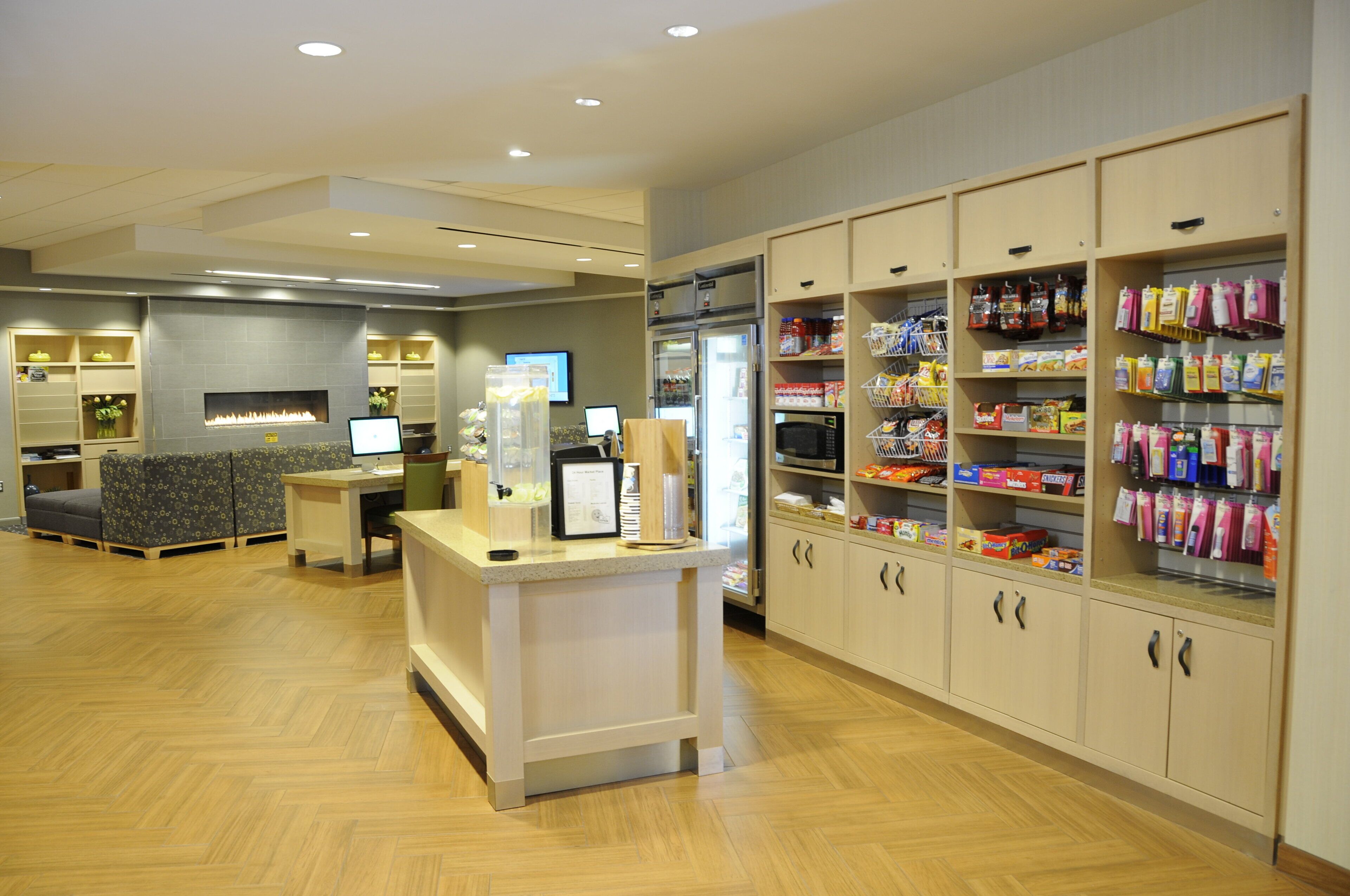 A modern interior with a reception desk, seating area, and a snack vending machine.