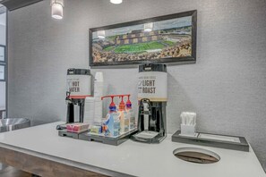 A coffee station with hot water, light roast coffee, and various beverage dispensers.
