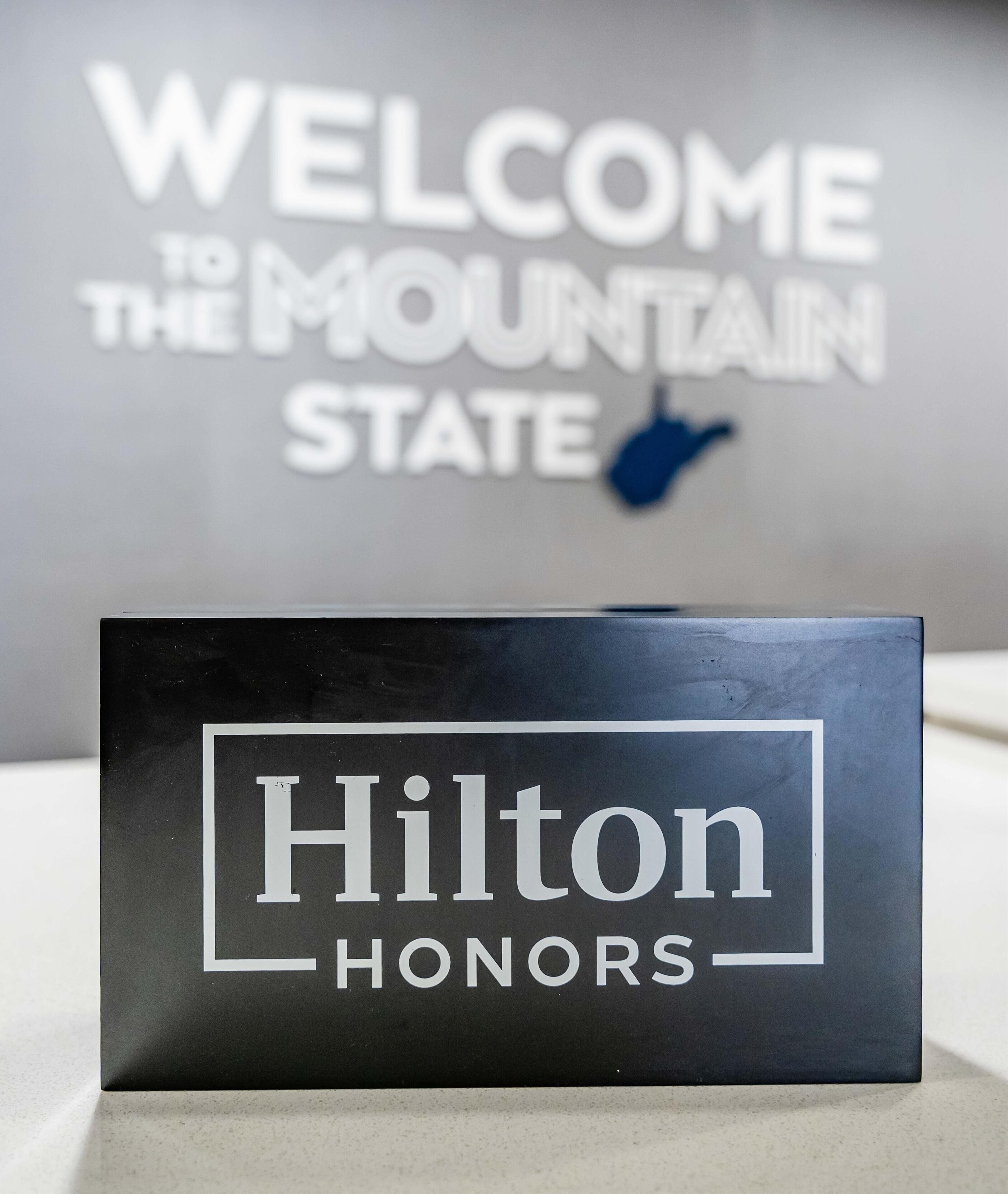 Un segnale nero con la scritta 'Hilton Honors' in lettere bianche.