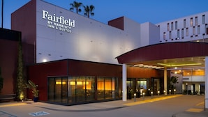 Una entrada de hotel moderna con un gran letrero que dice "Fairfield by Marriott Inn & Suites".