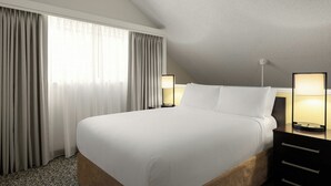A hotel room with a large bed, two bedside tables with lamps, a window with curtains, and a textured ceiling. - Residence Inn by Marriott Palo Alto Mountain View (Mountain View)