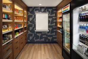 A narrow hallway with wooden cabinets on both sides, stocked with snacks and beverages.