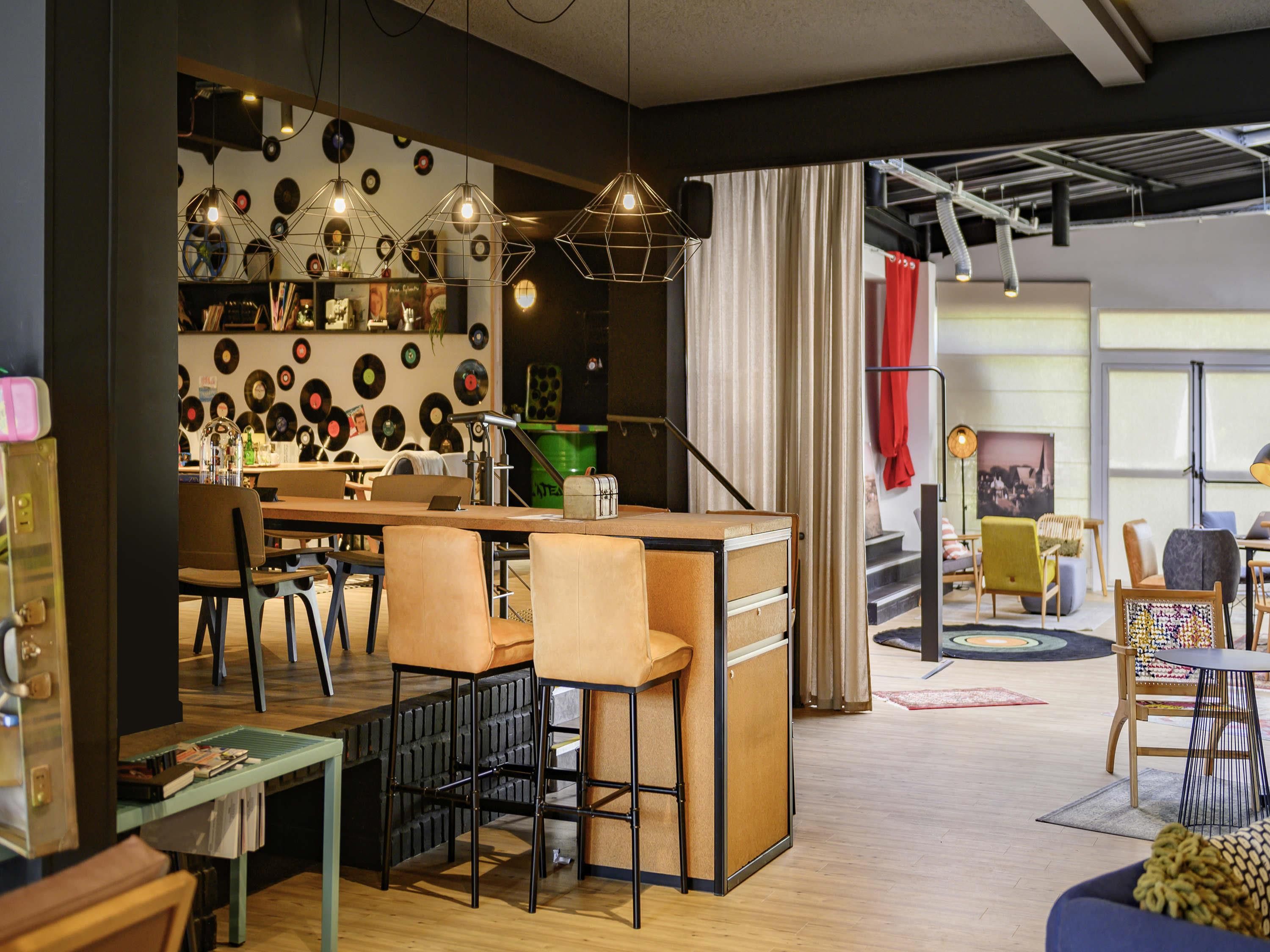 A modern interior with a bar area, seating, and a wall decorated with vinyl records.