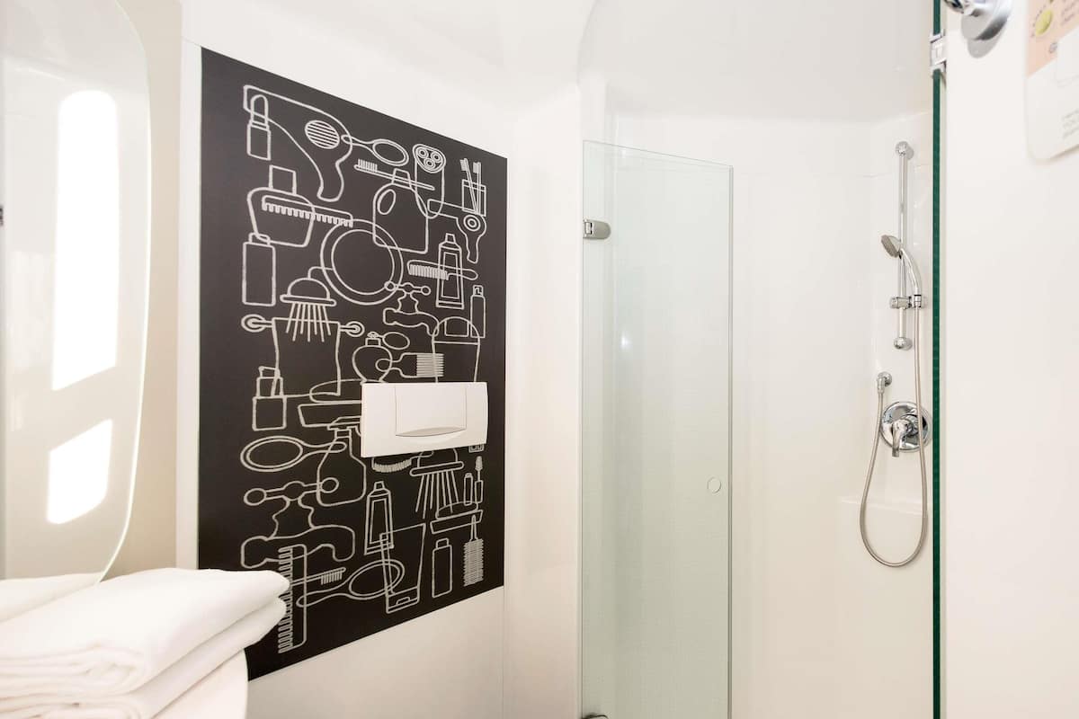 Ein Badezimmer mit Dusche, Toilette und Handtuch.