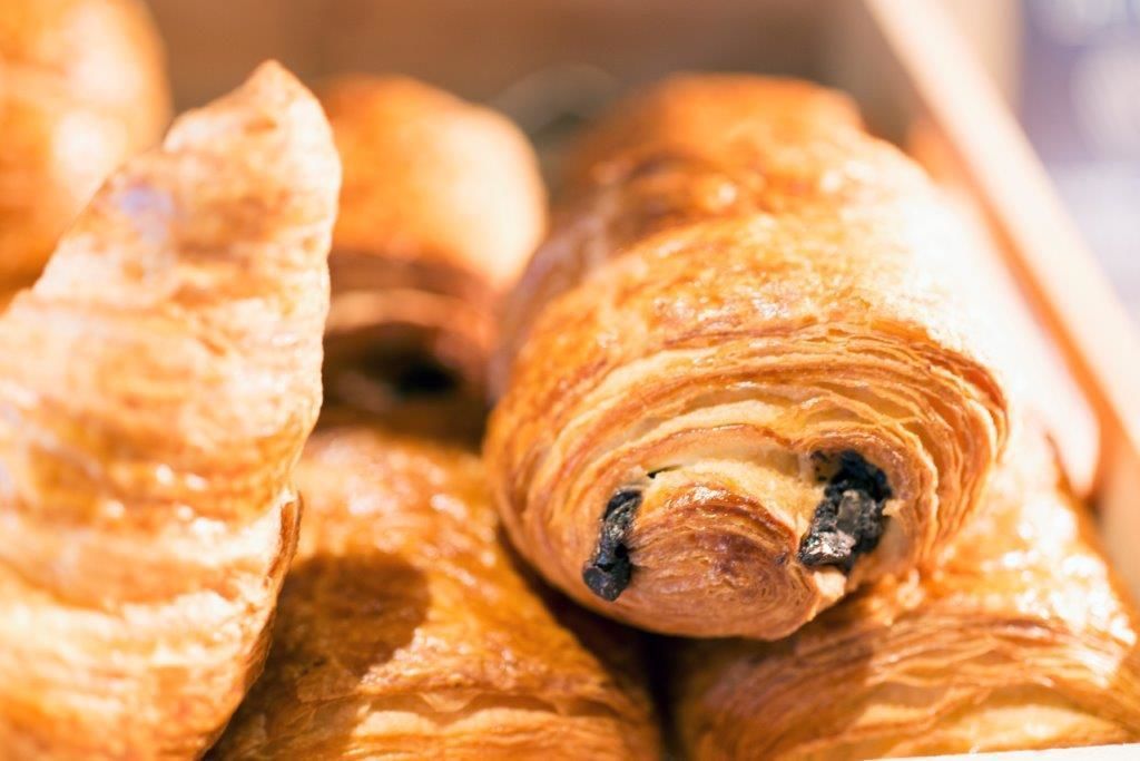 A close-up of a pastry, likely a croissant, with a visible filling.