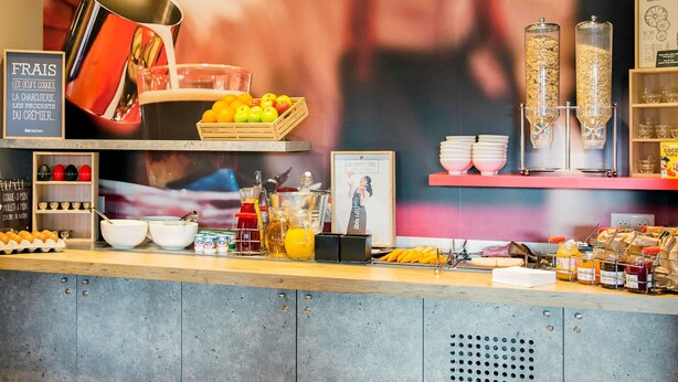 Una barra de desayuno con una variedad de alimentos, como frutas, salsas y bebidas.