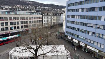 A cityscape with buildings, a bus, and a tent-like structure.