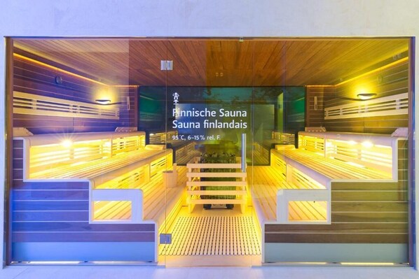 A sauna with wooden benches and a glass wall.
