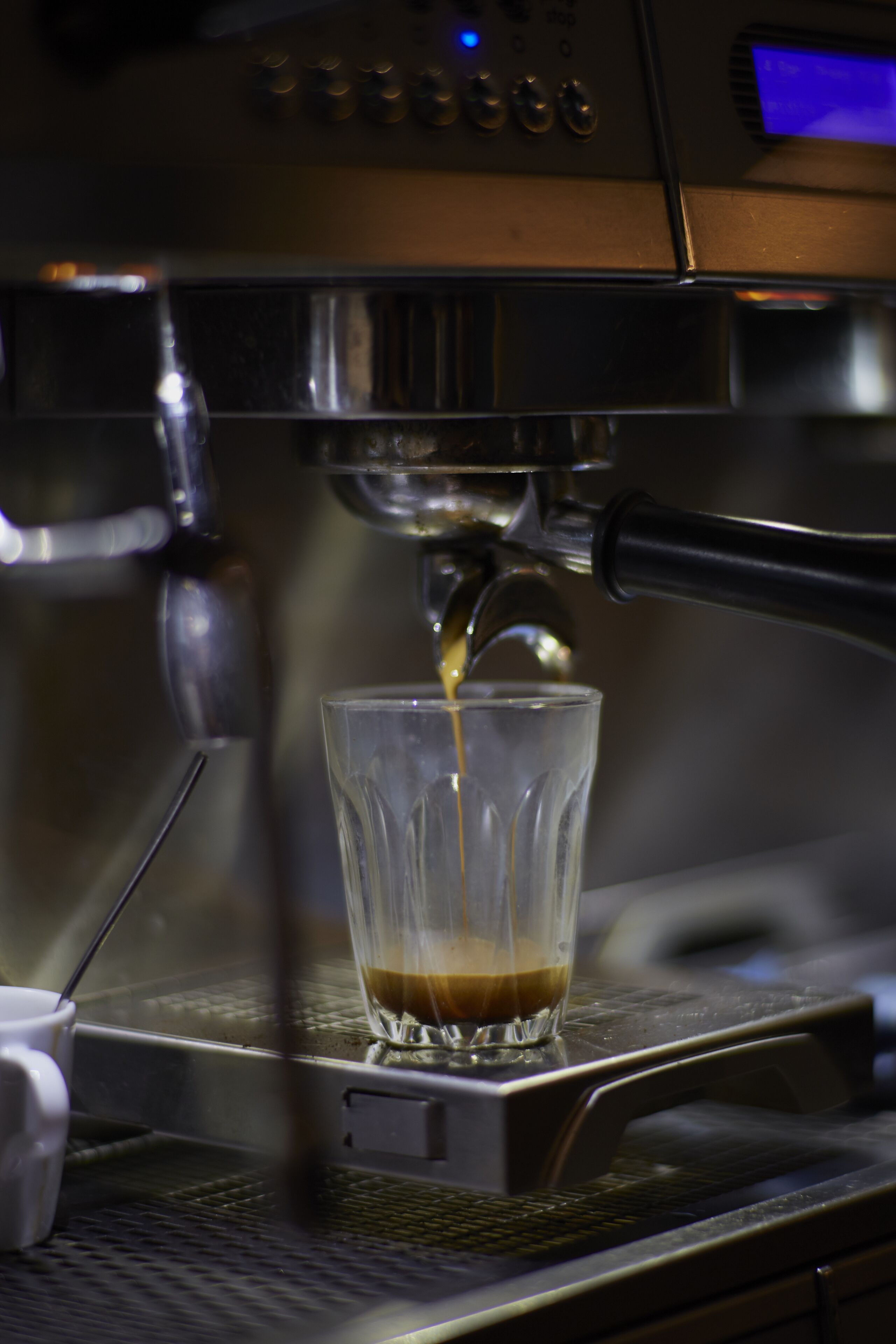 An espresso machine dispensing coffee into a glass cup.