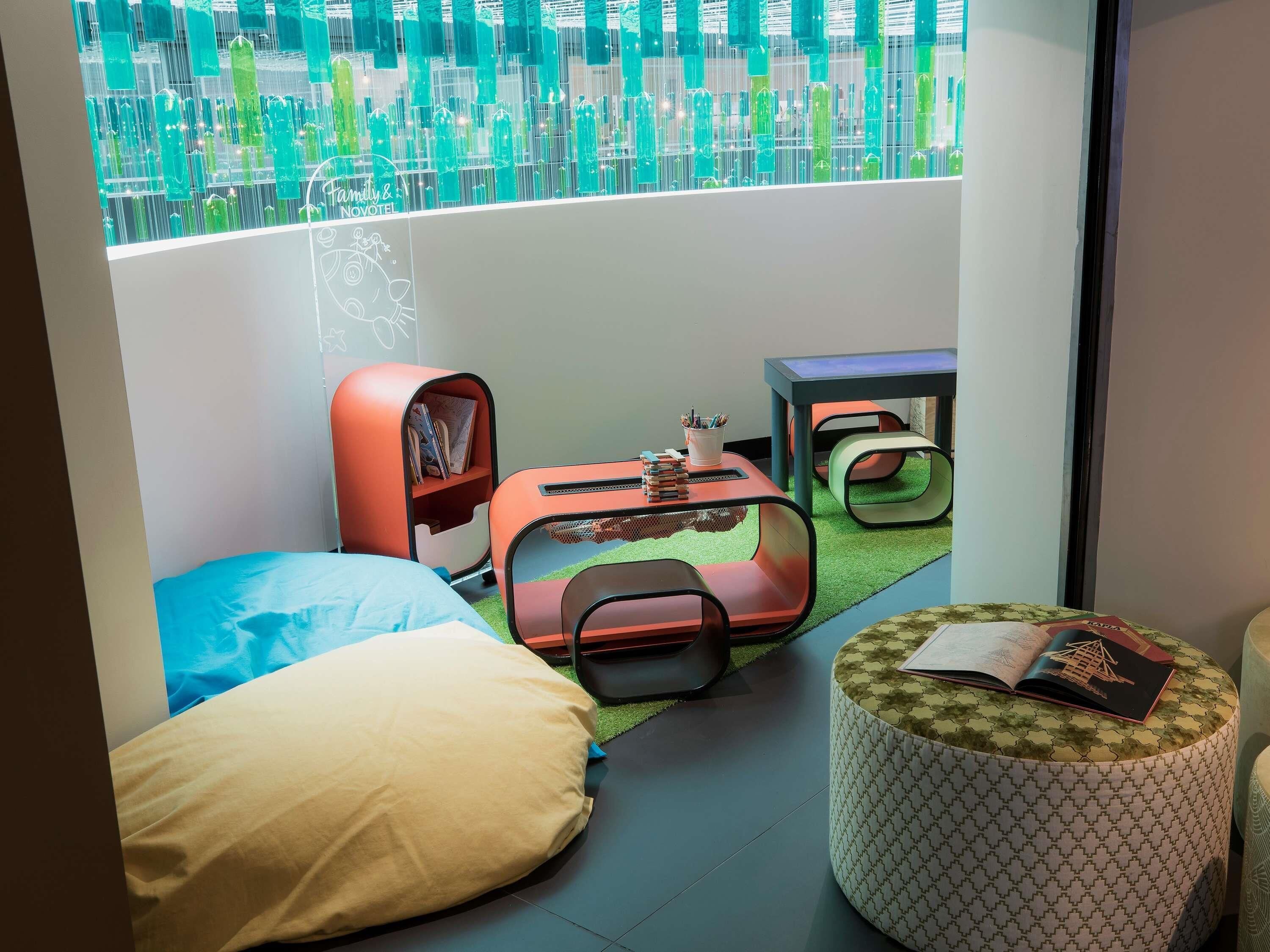 A modern room with a bed, a small table, a reading chair, and a sofa.