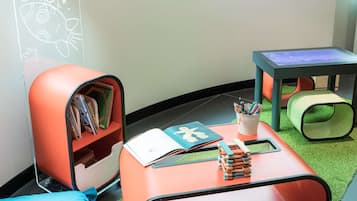 Children can play and learn in this cozy space with a bookshelf, table, and toys.