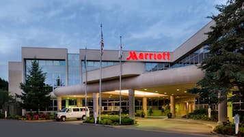 Ein Marriott Hotel mit modernem Design, das eine große Vordachkonstruktion und amerikanische Flaggen zeigt.