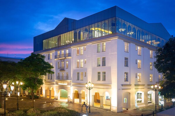 Experience the sleek, modern design of OSTERARIA, where a glass facade reflects the surroundings and a covered walkway invites you in.