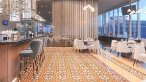 Un espace bar moderne avec un sol à motifs, des coins salon et une grande fenêtre offrant une vue sur le paysage urbain.