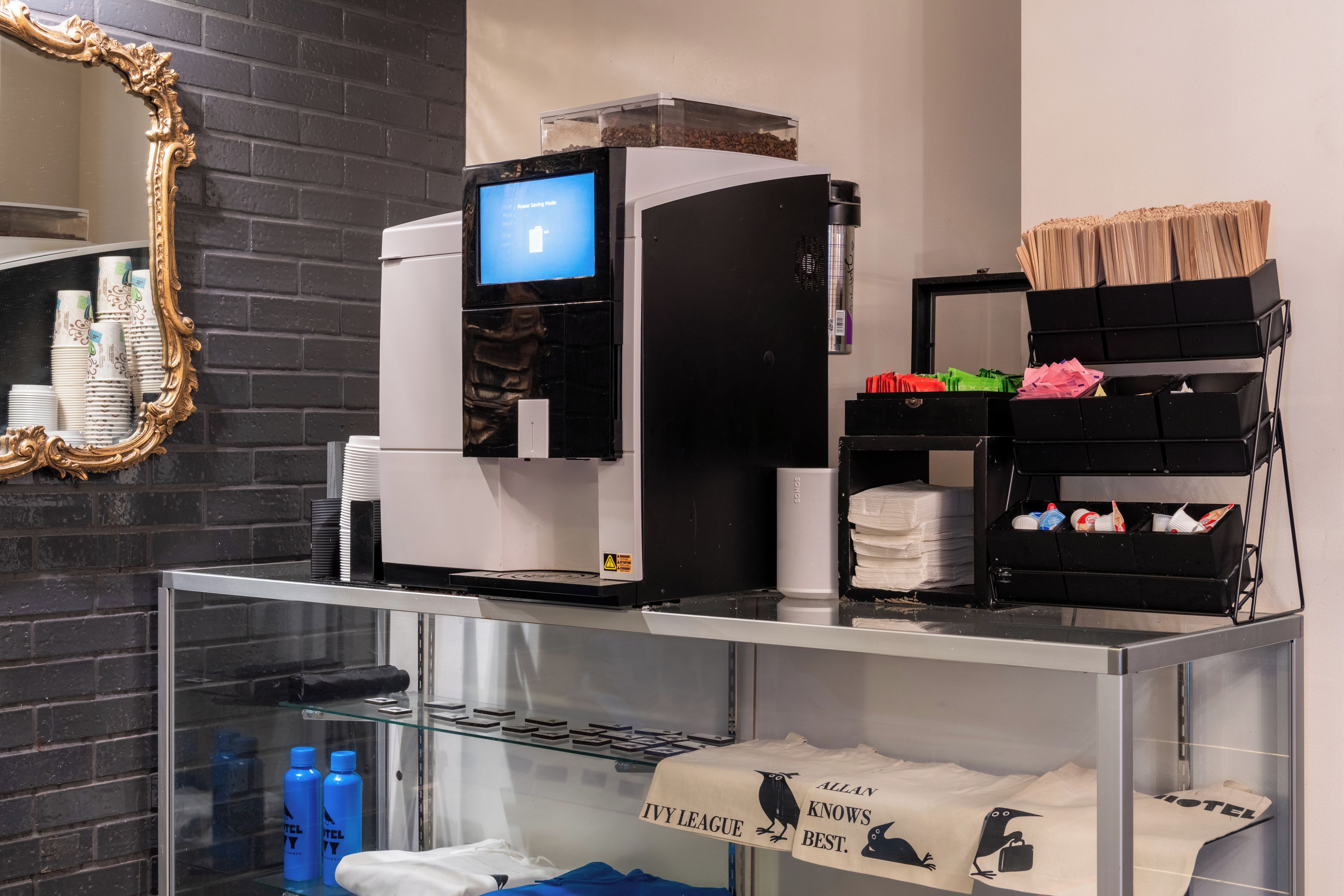 A coffee machine, a mirror, and a display of toiletries.
