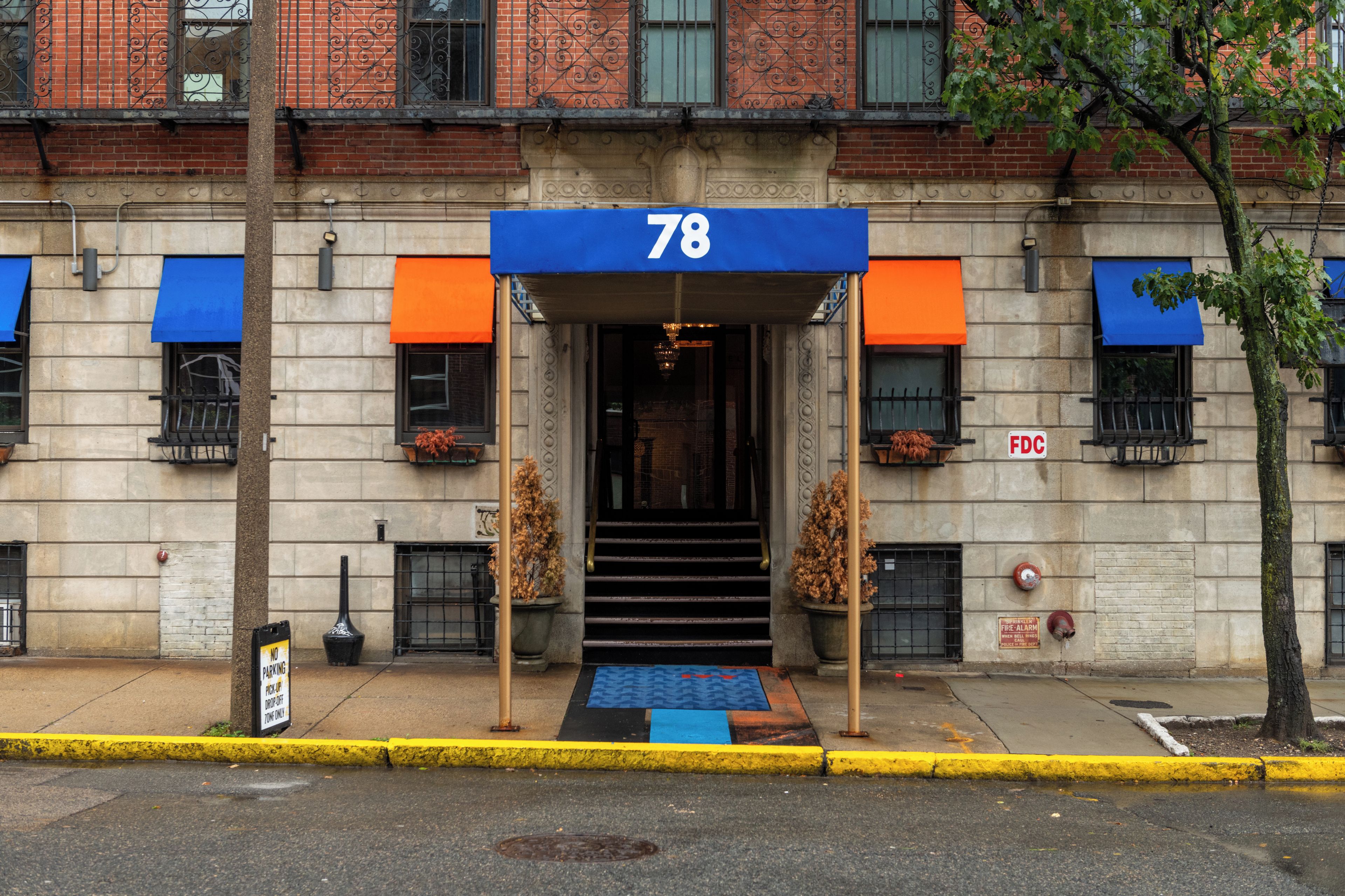 A building with a blue awning and the number 78 above the entrance.