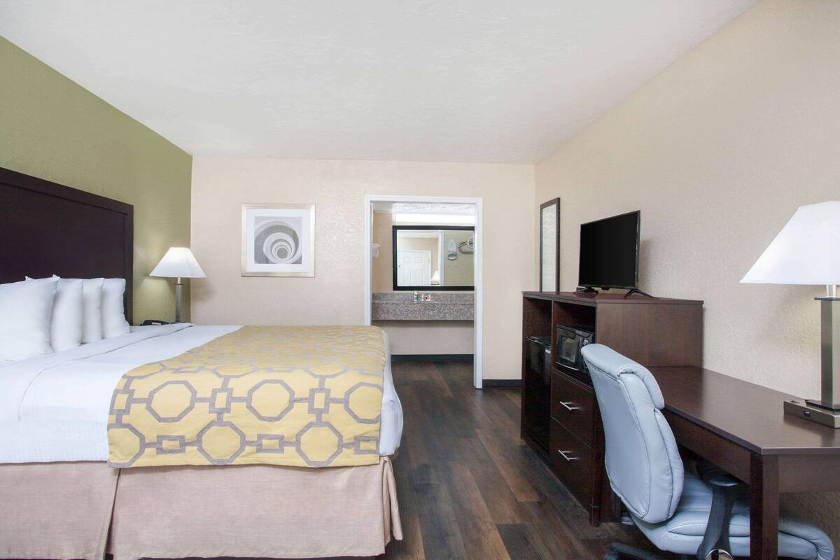 Une chambre d’hôtel équipée d’un lit, d’un bureau, d’une chaise et d’un téléviseur.