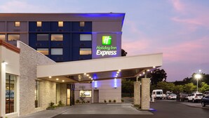 A Holiday Inn Express building with a modern design, featuring a prominent logo and a covered entrance area.