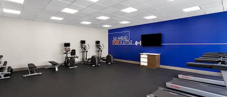 A gym with treadmills, exercise bikes, and weight machines.