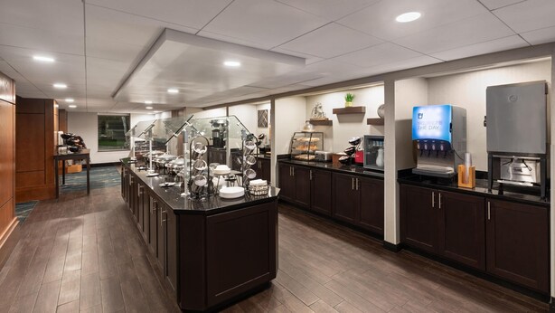 A modern kitchen with a central island, built-in appliances, and a coffee station.