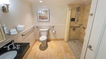 A bathroom with a toilet, sink, and shower.