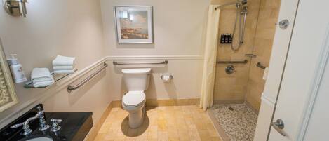 Et badeværelse med toilet, vask og brusebad.