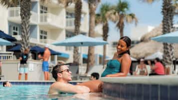 Una piscina al aire libre, camas de piscina con cargo, sombrillas