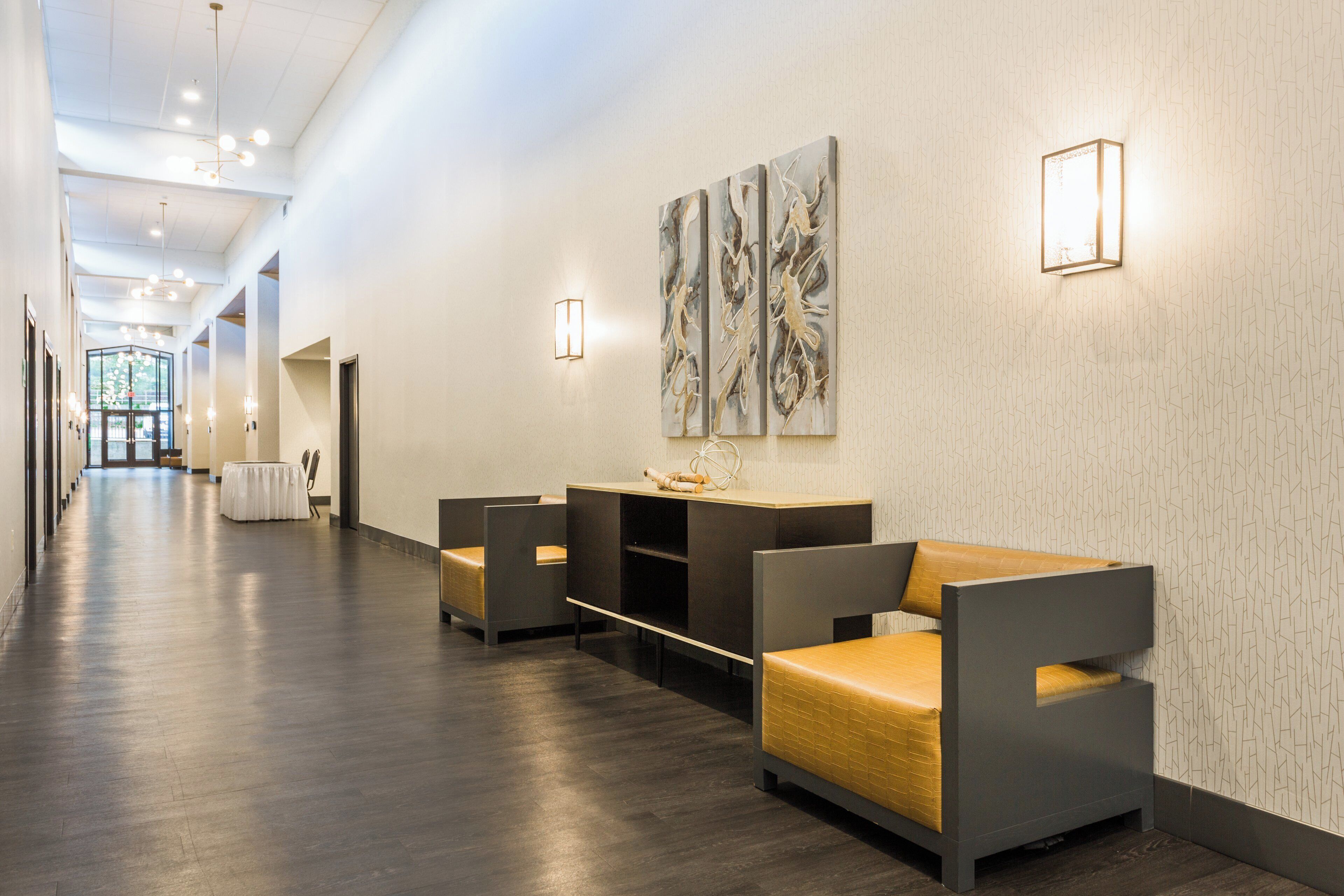 Eine Hotelhalle mit Rezeption, Sitzgelegenheiten und Blick zum Eingang.