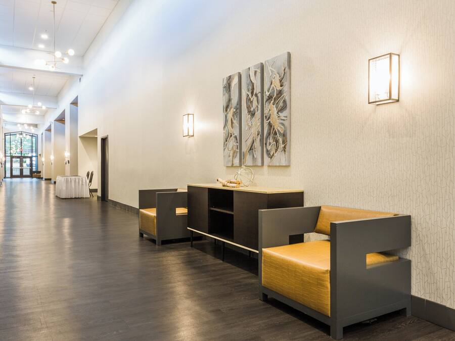 Eine Hotelhalle mit Rezeption, Sitzgelegenheiten und Blick zum Eingang.