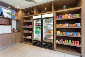 A snack bar with refrigerated display cases and shelves stocked with various snacks and beverages. - Holiday Inn Roanoke Airport – Conference CTR by IHG (Roanoke)