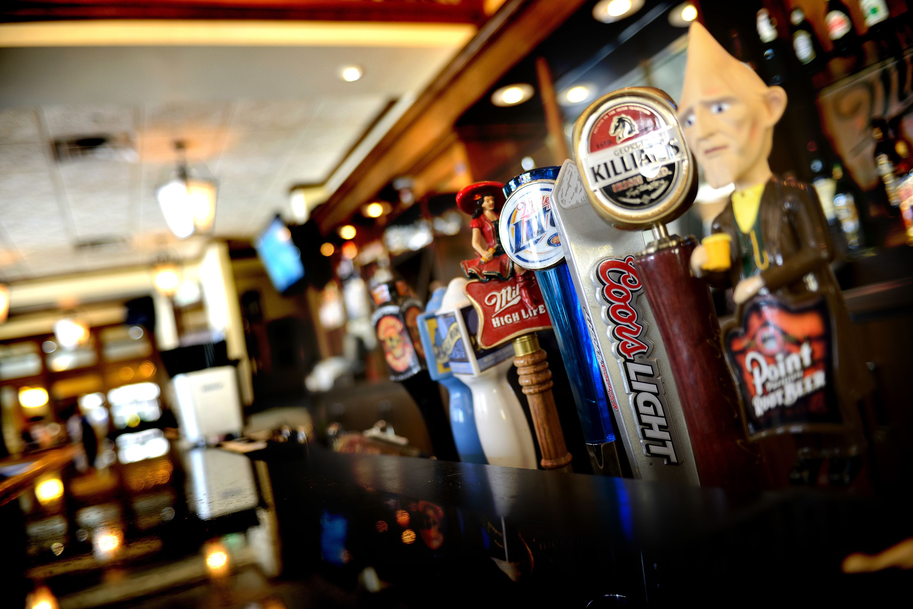 Un bar con diversi rubinetti per la birra e una grande statua di un uomo.