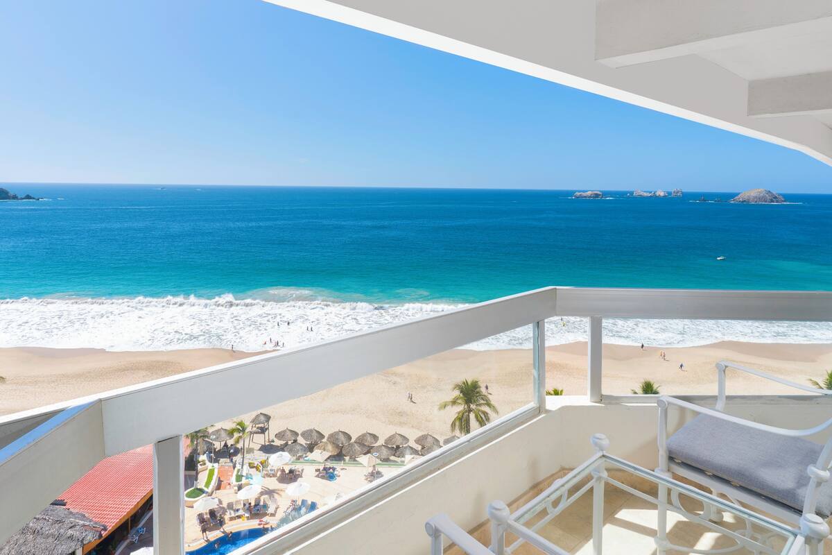 Un balcon avec vue sur une plage et l’océan.