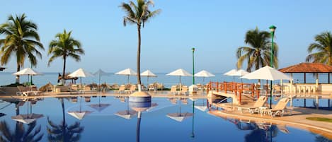 Una piscina al aire libre, sillones reclinables de piscina