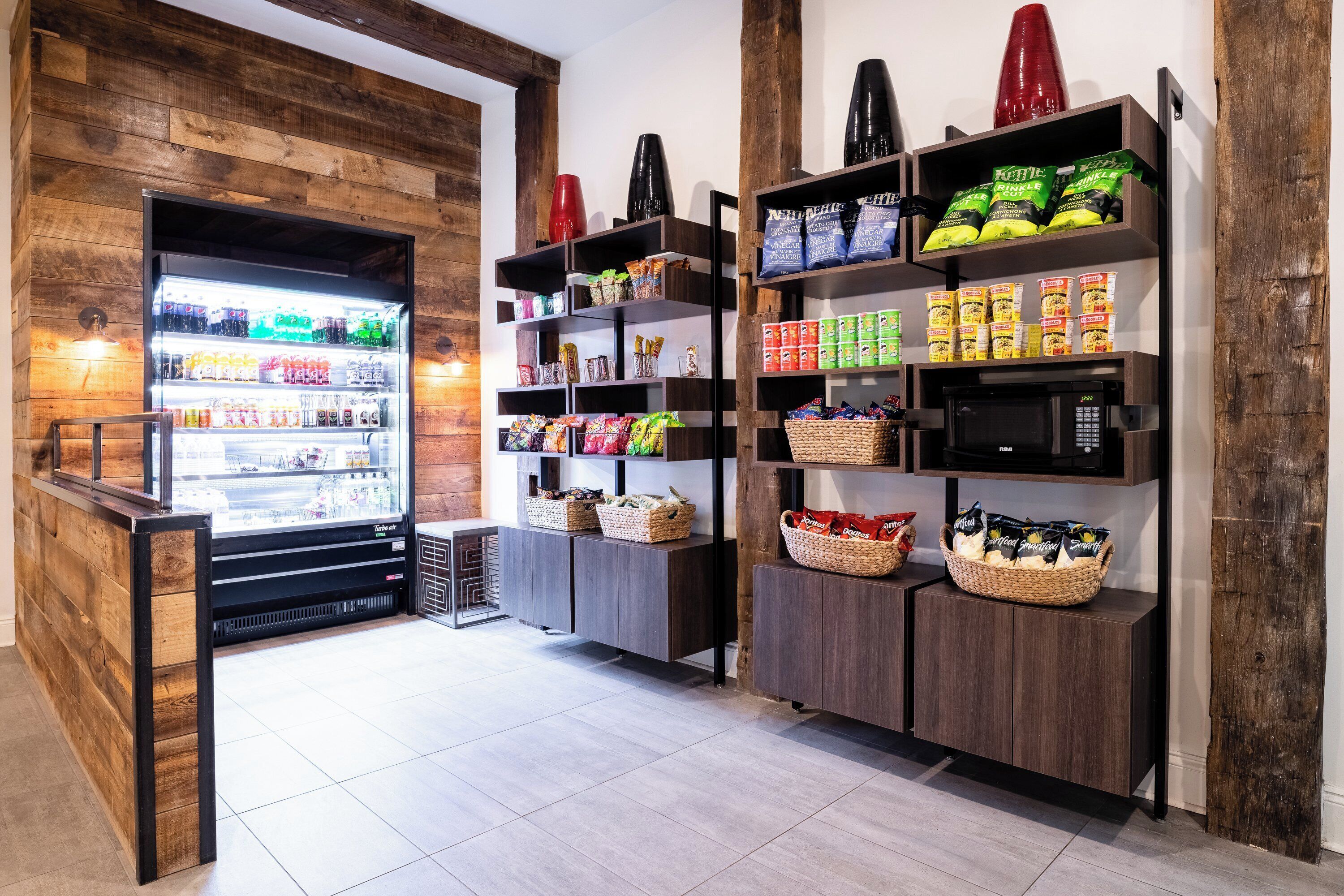 A store with a refrigerated display, shelves stocked with snacks, and a wooden wall.