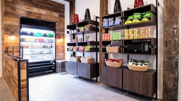 A store with a refrigerated display, shelves stocked with snacks, and a wooden wall.