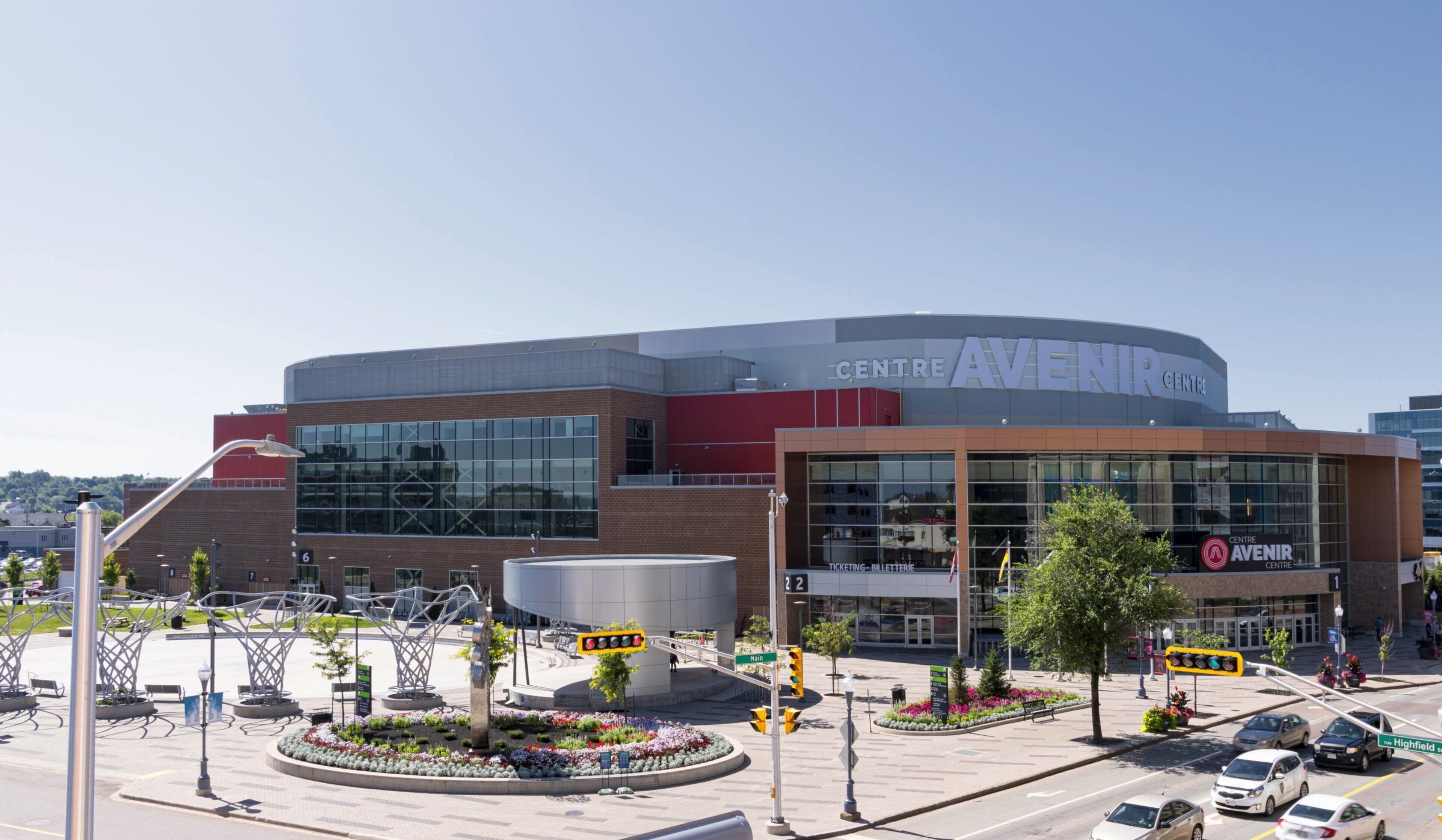 A modern building with a curved facade, large windows, and a prominent entrance.