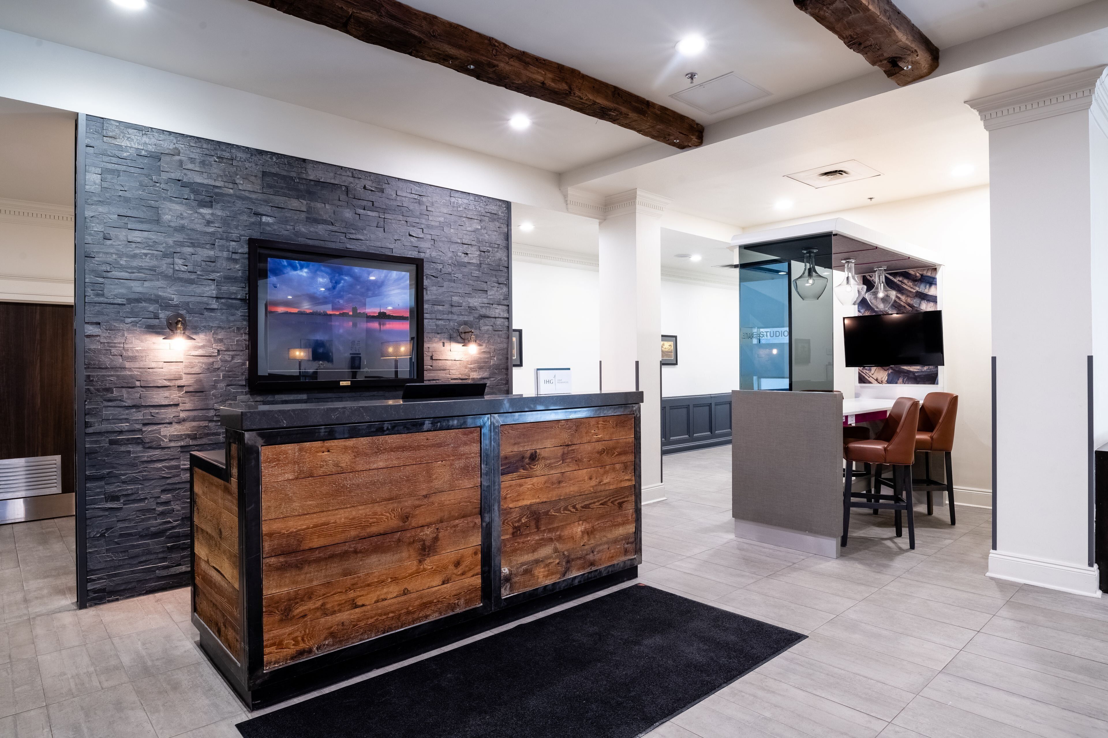 A modern kitchen with a stone backsplash, wooden cabinetry, and a built-in TV.