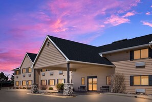 Stunning hotel with a symmetrical facade, featuring a central entrance and two wings.