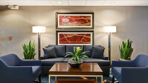 A lobby with a sofa, two armchairs, a coffee table with a plant, and two floor lamps. - Hampton Inn Charlotte-Gastonia (Gastonia)